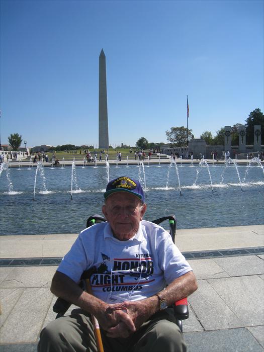 WW II Hero Bob Lamp at the World War II Memorial with the Washington Monument in the background.