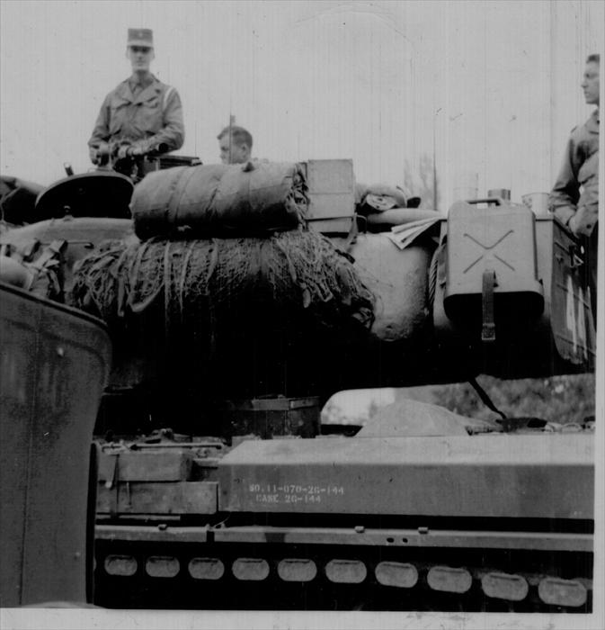 John Tubinis, PFC, 1st ID HQ CO, standing in the turret of a M-34 tank carrying a 50-cal. machine gun.  A warm weather maneuver.  Dad umpired as indicated by the white engineer's tape around his left shoulder.  Germany 1951-1953.