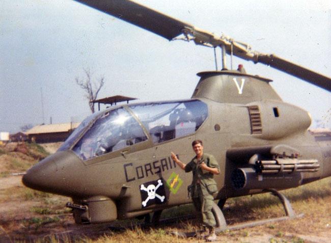 Eldon standing in front of a Cobra Corsair helicopter in Vietnam.