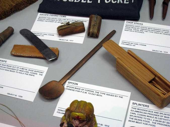 Artifacts made by Carl while he was in the POW camp. Some served practical needs like a spoon, rounded knife, fishing items and chop sticks while others kept Carl's mind off his current situation.