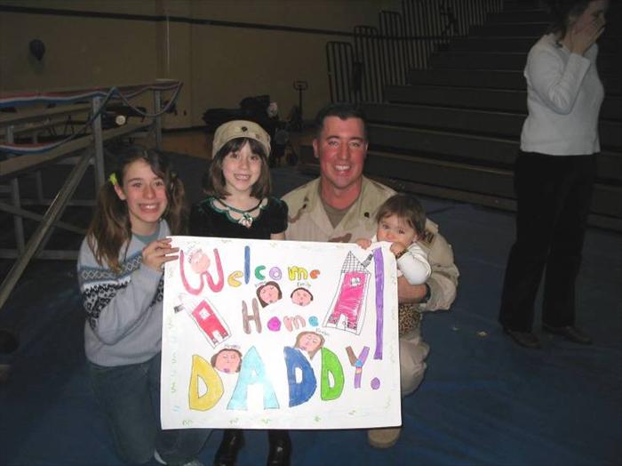 Picture of me and my girls with the 'Welcome Home Daddy' sign they made just for me!  March 2005.