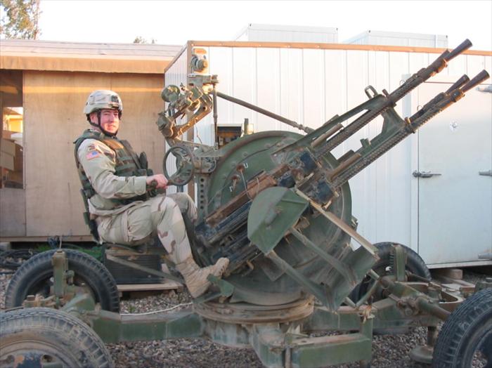 Photo op; me sitting on an old Russian-made, quad machine guns-AAA (Anti Aircraft Artillery) weapon system.